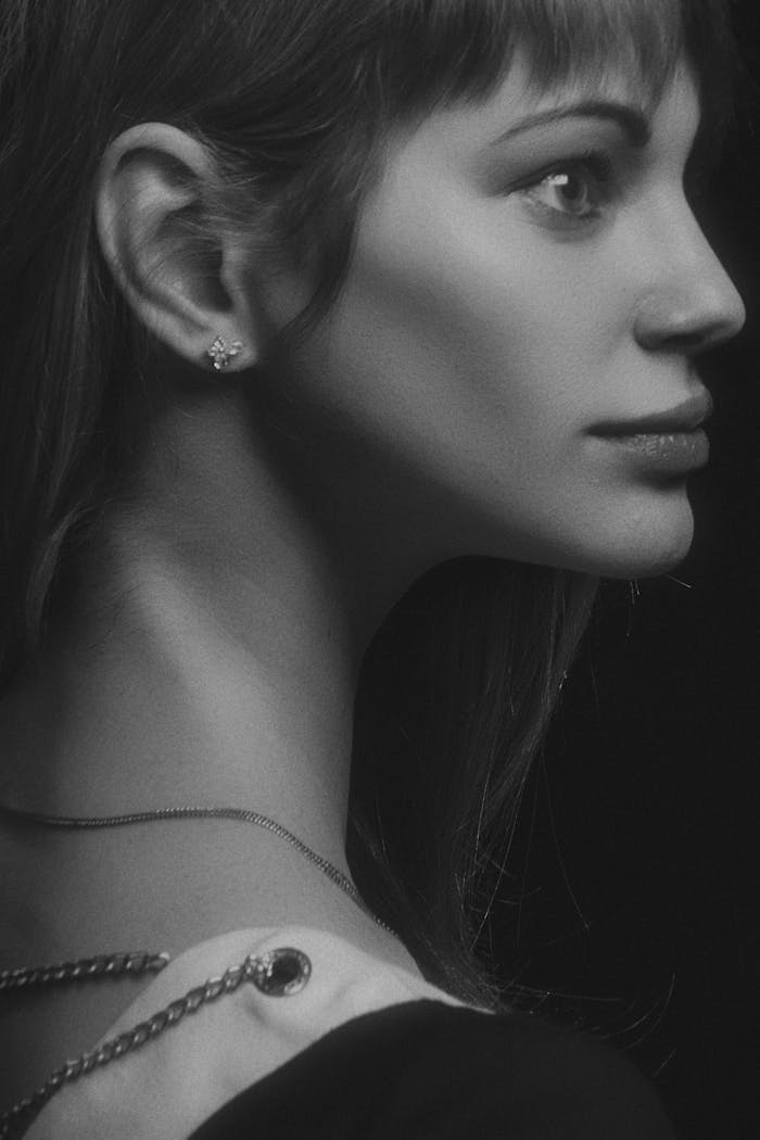 Stunning black and white side profile of a woman with elegant jewelry, highlighting beauty and style.